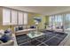 Bright, staged living room with neutral furniture, large windows, and stylish rug at 1430 Gulf Blvd # 204, Clearwater Beach, FL 33767