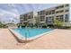 Exterior view of a refreshing community pool with nearby resort-style amenities and a multi-story building in the background at 1430 Gulf Blvd # 204, Clearwater Beach, FL 33767