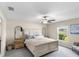 Spacious main bedroom with a ceiling fan and backyard view at 15410 Miller Creek Dr, Ruskin, FL 33573