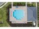 Aerial view of community pool with lounge chairs, umbrellas, and a nearby covered area with tables and chairs at 17925 Nadine Pl, Nokomis, FL 34275