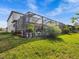 Landscaped backyard with large screened enclosure at 19270 Briarbrook Dr, Tampa, FL 33647