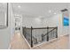 Upstairs hallway with wood-look floors and wrought iron railing with a view of the first floor at 19270 Briarbrook Dr, Tampa, FL 33647