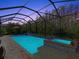 Inviting screened pool and spa at night with colorful lighting at 19270 Briarbrook Dr, Tampa, FL 33647
