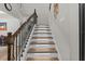 Close-up of a modern staircase with wooden steps, wrought iron railing, and integrated LED lighting at 19270 Briarbrook Dr, Tampa, FL 33647