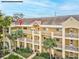 Two-story condo building with palm trees and lush landscaping at 2231 Utopian E Dr # 321, Clearwater, FL 33763