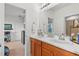 Bathroom featuring double vanity, wood cabinets and a view into an adjacent room at 33975 Astoria Cir, Wesley Chapel, FL 33545
