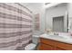 Bathroom with wood cabinets, grey shower curtain, and decor at 33975 Astoria Cir, Wesley Chapel, FL 33545