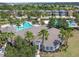Gorgeous community clubhouse and pool area with lush landscaping and swaying palm trees at 33975 Astoria Cir, Wesley Chapel, FL 33545