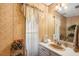 Small bathroom with beige vanity and floral-patterned wallpaper at 5105 N 45Th St, Tampa, FL 33610