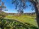 Serene waterfront view with lush greenery and mature trees at 5212 Golf Links Blvd, Zephyrhills, FL 33541