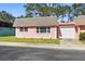 Pink house with a white garage door and well-maintained lawn at 7075 Lafayette N, Pinellas Park, FL 33781