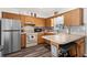 Well-lit kitchen with stainless steel refrigerator, wooden cabinetry, and cozy breakfast bar at 7075 Lafayette N, Pinellas Park, FL 33781