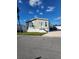 Tan single-wide manufactured home with white trim, steps, and a paved driveway at 919 50Th W Ave, Bradenton, FL 34207
