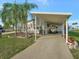 Mobile home with carport, landscaping, and palm trees at 118 Saint Pierres Way, Apollo Beach, FL 33572
