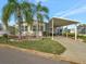 Mobile home with carport, landscaping, and palm trees at 118 Saint Pierres Way, Apollo Beach, FL 33572