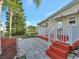Red steps lead up to a deck with white railings and a view of the backyard at 118 Saint Pierres Way, Apollo Beach, FL 33572