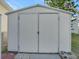White storage shed with double doors, providing ample storage space at 118 Saint Pierres Way, Apollo Beach, FL 33572