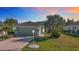 Single-story home with green exterior and two-car garage at 1320 Misty Greens Dr, Sun City Center, FL 33573