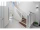 Modern staircase with white railings and dark wood steps at 19554 Roseate Dr, Lutz, FL 33558