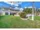 Landscaped backyard of two-story house with lush grass and manicured bushes at 30 Dolphin Dr, Treasure Island, FL 33706