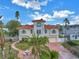 Two-story waterfront home with red tile roof and palm trees at 30 Dolphin Dr, Treasure Island, FL 33706