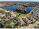 Aerial view of lakefront community with pool and lush landscaping at 7051 Twisting Pines Loop, Zephyrhills, FL 33541