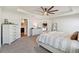 Bright main bedroom with a king-size bed, dresser, and view of the kitchen at 7051 Twisting Pines Loop, Zephyrhills, FL 33541