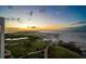 Beautiful sunset view of the beach, green grass, and walkway to the water at 800 Collany Rd # 605 & 606, Tierra Verde, FL 33715