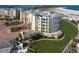 Beautiful exterior view of a beachfront condo with manicured landscaping and lush green grass at 800 Collany Rd # 605 & 606, Tierra Verde, FL 33715