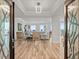 Bright and spacious living room featuring wood floors, a modern chandelier, and beautiful ocean views framed by a decorative doorway at 800 Collany Rd # 605 & 606, Tierra Verde, FL 33715