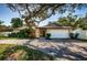 Single-story home with a large tree and a paved driveway at 1609 Lakeview Rd, Clearwater, FL 33756