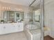 Elegant bathroom with a soaking tub, double vanity, and glass shower at 2012 Longliner Loop, Wesley Chapel, FL 33543