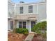 Light-blue townhouse with a welcoming front door, complemented by manicured landscaping at 2345 Lake Woodberry Cir, Brandon, FL 33510