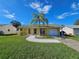 Cute yellow house with a palm tree, white rock pathway, and attached garage at 3141 Ludlow Dr, New Port Richey, FL 34655