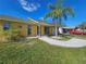 Yellow house with palm tree, landscaped yard, and attached garage at 3141 Ludlow Dr, New Port Richey, FL 34655