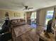 Living room with brown leather sofa, wood floors, and a ceiling fan at 3141 Ludlow Dr, New Port Richey, FL 34655