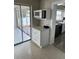 Compact kitchenette featuring a microwave and white cabinets, near a sunroom with waterfront views at 485 41St Ave, St Pete Beach, FL 33706