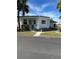 White single-wide manufactured home with carport and palm trees at 4851 W Gandy Blvd # B1L30, Tampa, FL 33611