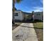 Gravel driveway leading to a white manufactured home with a covered walkway at 4851 W Gandy Blvd # B1L30, Tampa, FL 33611