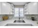 Kitchen sink with white quartz countertops and a mosaic backsplash at 5700 Marble Dr, New Port Richey, FL 34652