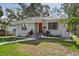 Charming bungalow with gray siding, red door, and landscaped lawn at 946 23Rd S Ave, St Petersburg, FL 33705