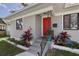 Steps leading to red front door, flanked by tropical plants at 946 23Rd S Ave, St Petersburg, FL 33705