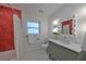 Bathroom with red tile shower, white vanity, and a window at 1161 Howard St, Clearwater, FL 33756