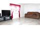 Living room with brown couch and TV at 12663 Eddington Rd, Spring Hill, FL 34609