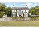 Two-story home with white exterior, dark roof, and manicured lawn at 140 Brightwaters Ne Blvd, St Petersburg, FL 33704