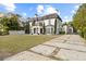 Two-story house with a paved driveway, landscaping, and a white exterior at 140 Brightwaters Ne Blvd, St Petersburg, FL 33704
