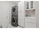 Bright laundry room with washer, dryer, cabinets, and a utility sink at 140 Brightwaters Ne Blvd, St Petersburg, FL 33704