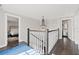 Upstairs hallway with hardwood floors, chandelier, and a view of a bedroom at 140 Brightwaters Ne Blvd, St Petersburg, FL 33704