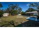 Large backyard with a covered patio area, lawn, shed, and mature landscaping at 215 35Th Ne Ave, St Petersburg, FL 33704
