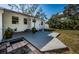 Back of house featuring a wooden deck, brick pathway, and green lawn with mature trees at 215 35Th Ne Ave, St Petersburg, FL 33704